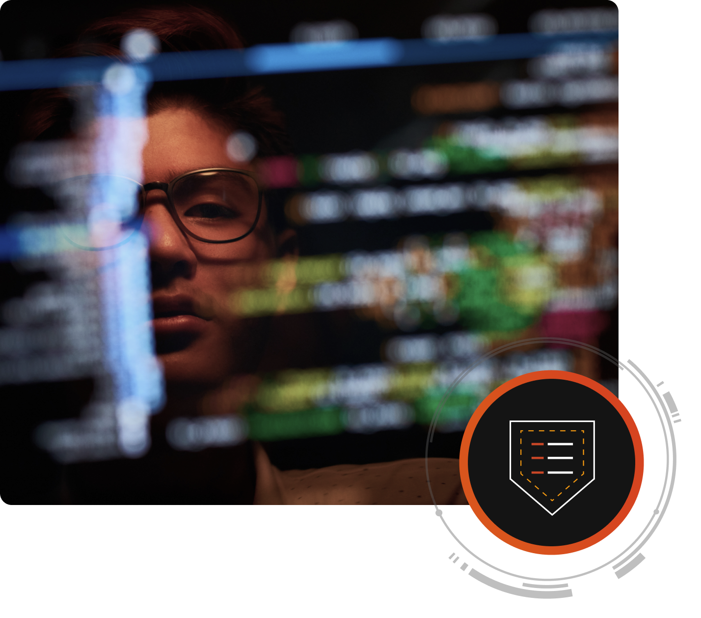 Visage d’une personne se reflétant sur un écran d’ordinateur affichant du code de cybersécurité.